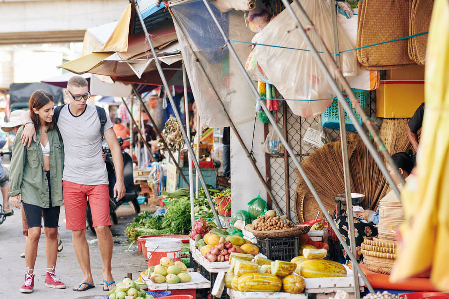 pareja de turista caminando por mercado chino observando todo